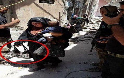 ISIS female suicide bomber pictured while holding a trigger and carrying a baby